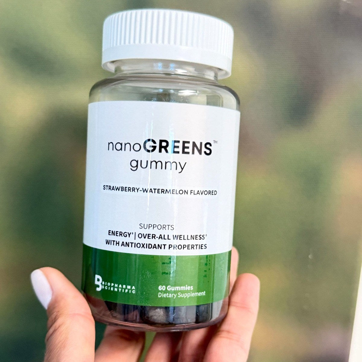 NanoGreens Gummies bottle in hand