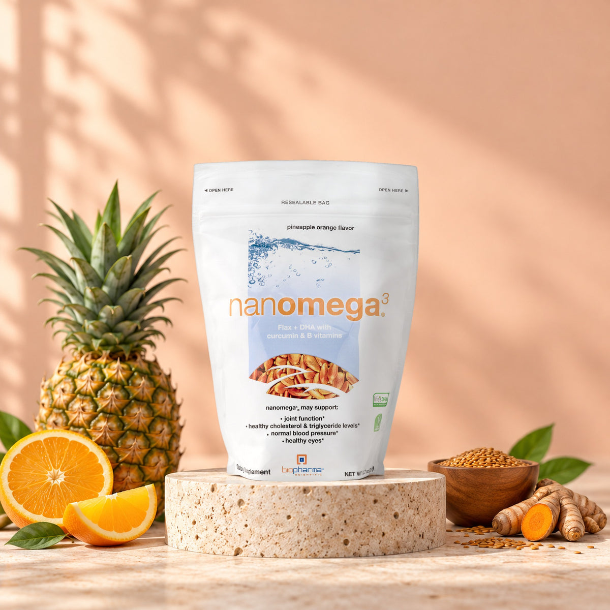 NanoMega Pineapple Orange pouch in a bright studio still life with fresh ingredients
